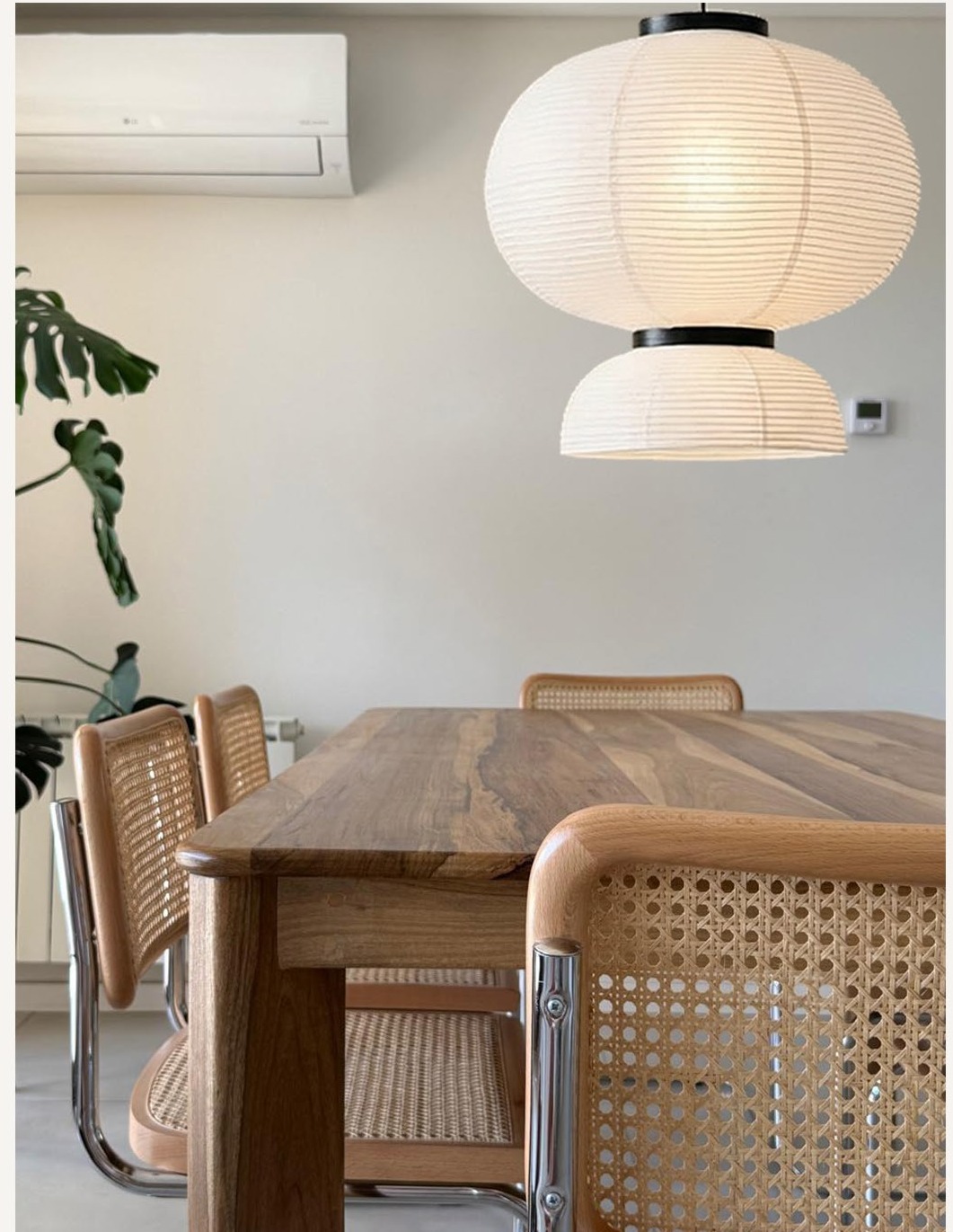 Comedor con sillas de caña y lámparas de papel